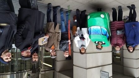 Ten people stand in front of DfT, including one wearing a train outfit
