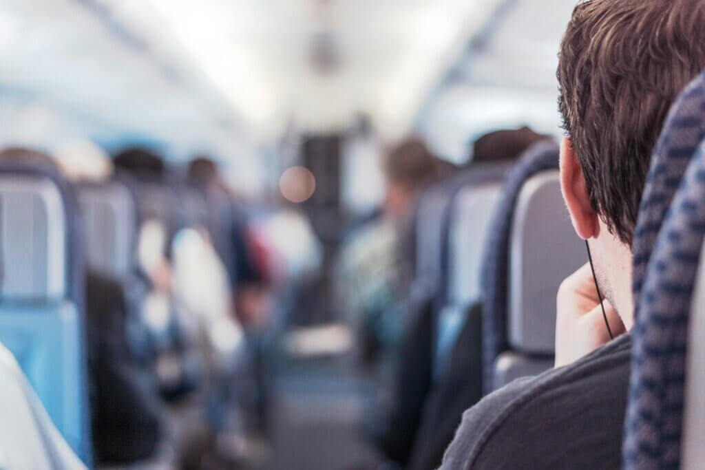 A person seated on a train viewed from behind